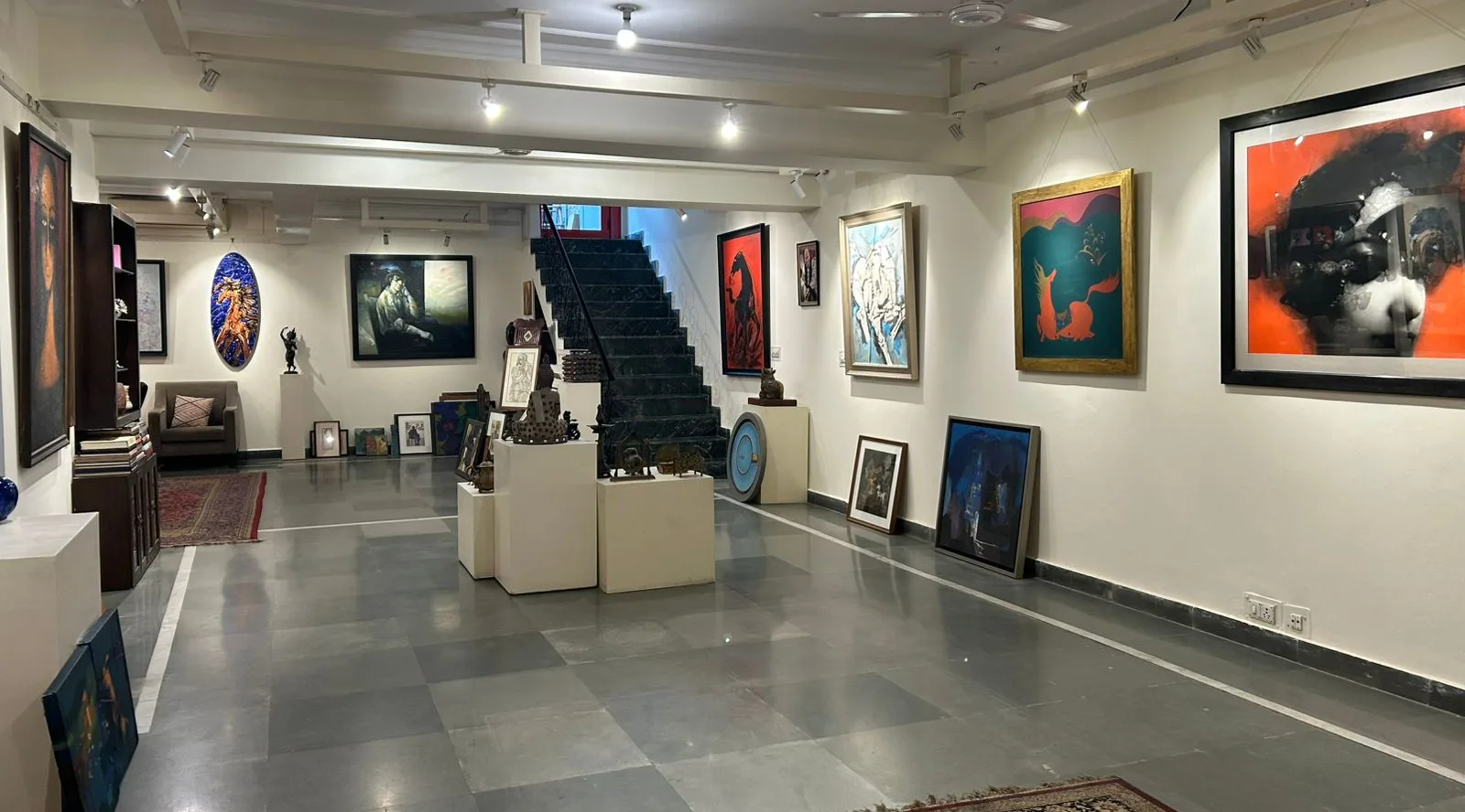 Gallery One — main exhibition hall with paintings, sculptures, and central staircase